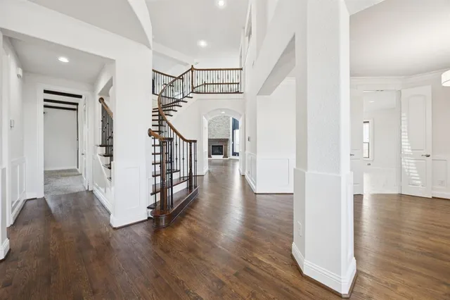 a view of a hallway with wooden floor and staircase
