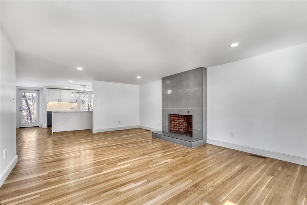 6 Spring Lane Saugus, MA 01906 - Photo 11 of 37 a view of an empty room with wooden floor fireplace and a window