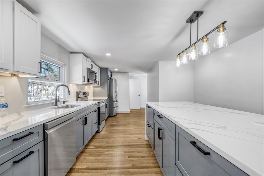 6 Spring Lane Saugus, MA 01906 - Photo 4 of 37 a large kitchen with kitchen island a sink a stove oven a counter space and cabinets