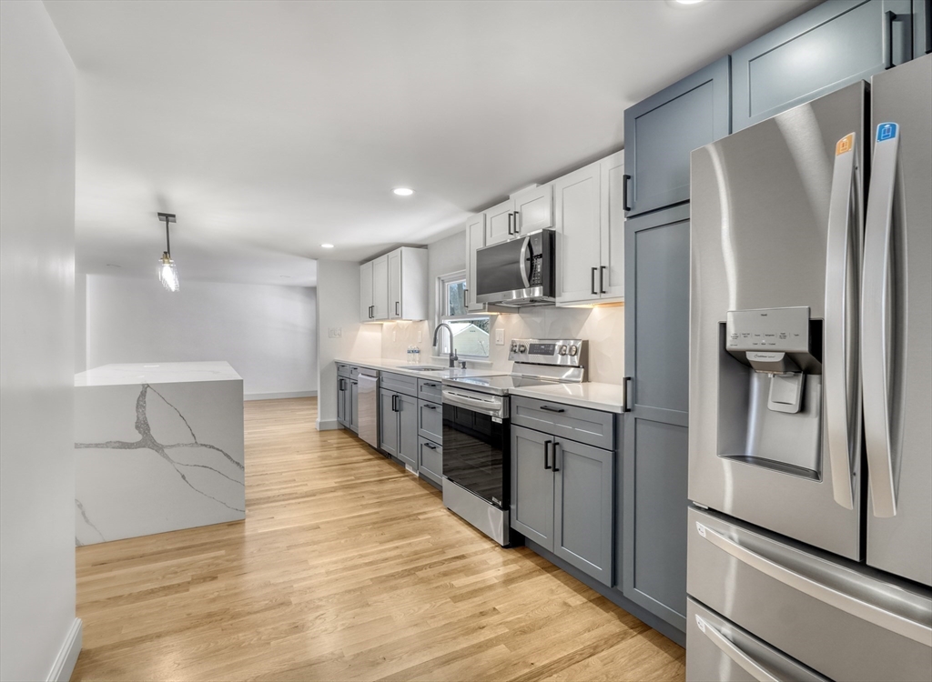 6 Spring Lane Saugus, MA 01906 - Photo 5 of 37 a large kitchen with stainless steel appliances kitchen island a stove a refrigerator a sink and dishwasher with white cabinets
