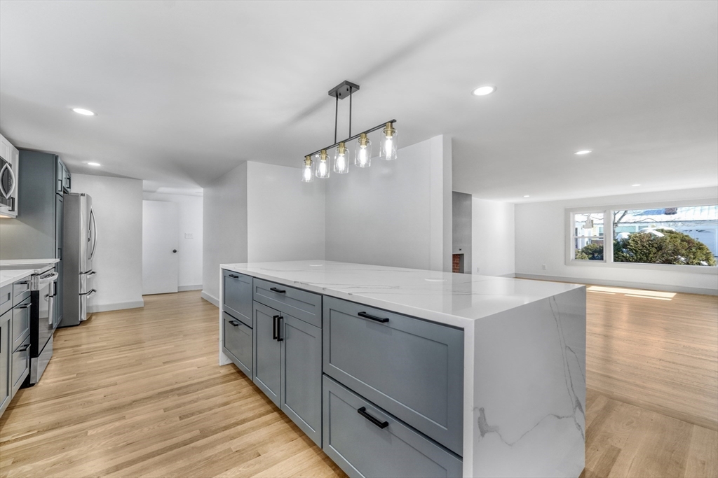 6 Spring Lane Saugus, MA 01906 - Photo 7 of 37 a large white kitchen with a large island oven a sink and stainless steel appliances