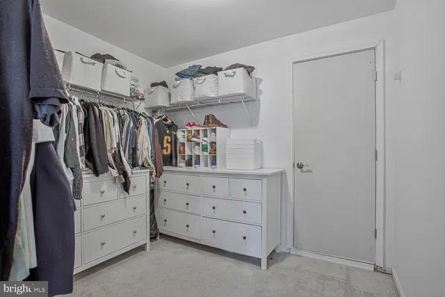 a view of walk in closet with clothes