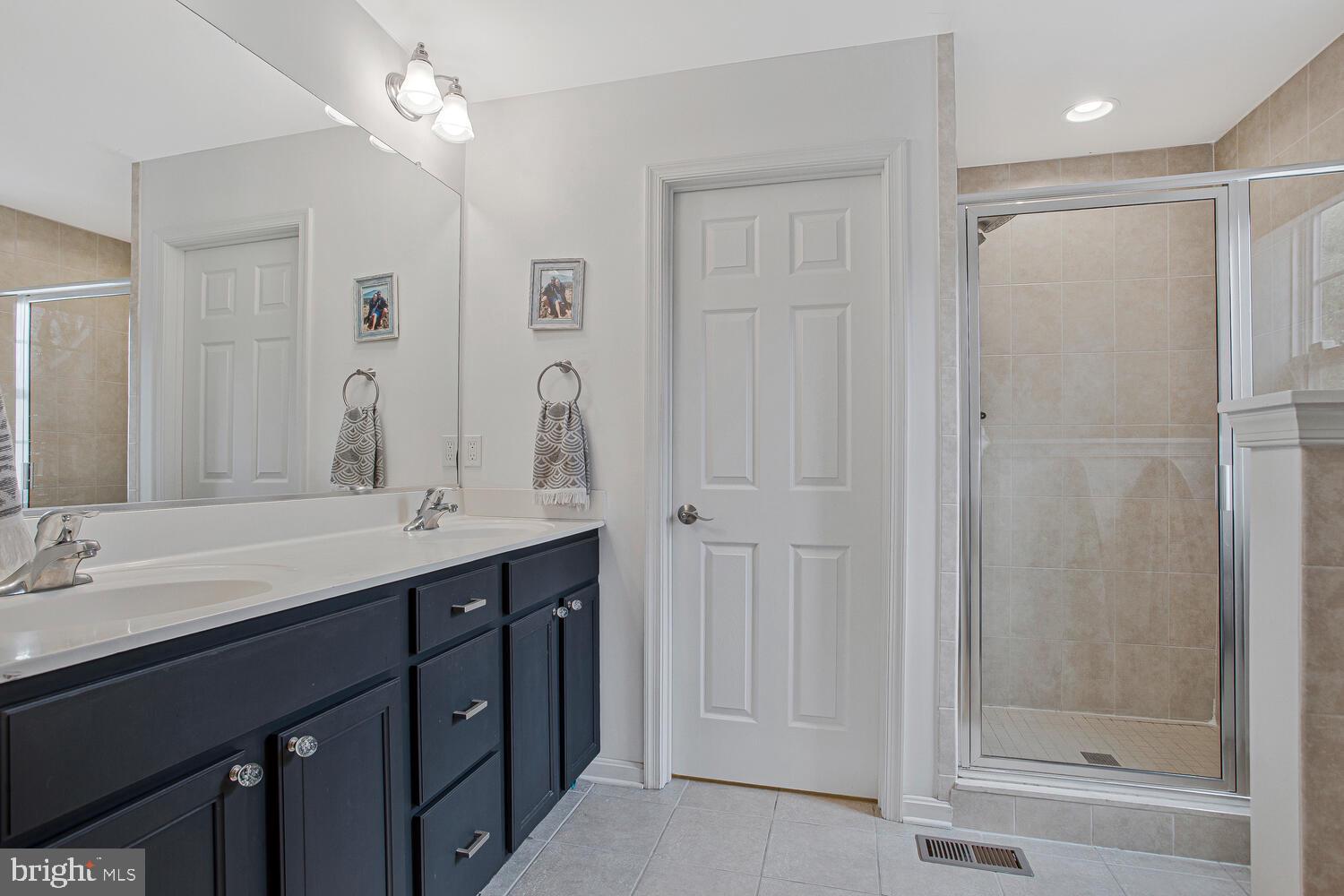 703 Trapper Way Deale, MD 20751 - Photo 9 of 18 a bathroom with a double vanity sink mirror and shower