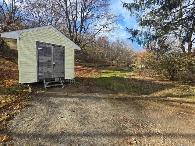 a view of a house with backyard and trees