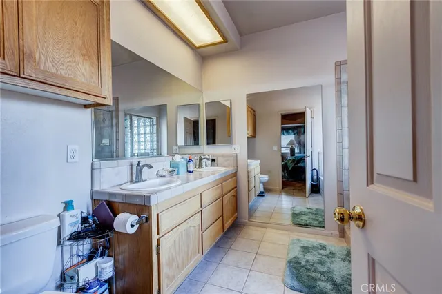 a bathroom with a granite countertop toilet a sink and a large mirror