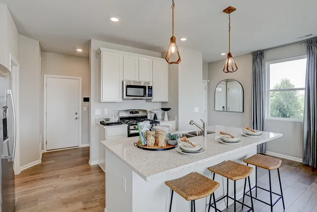 a kitchen with sink refrigerator dining table and chairs