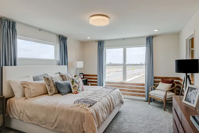 a spacious bedroom with a bed and a large window