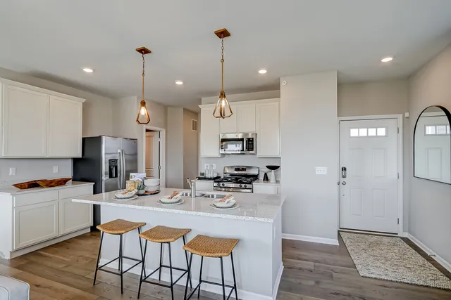 a kitchen with stainless steel appliances kitchen island granite countertop a sink and refrigerator
