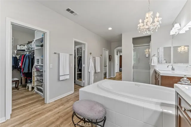 a spacious bedroom with a bed and a chandelier