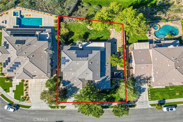 an aerial view of a house with a yard and a large tree