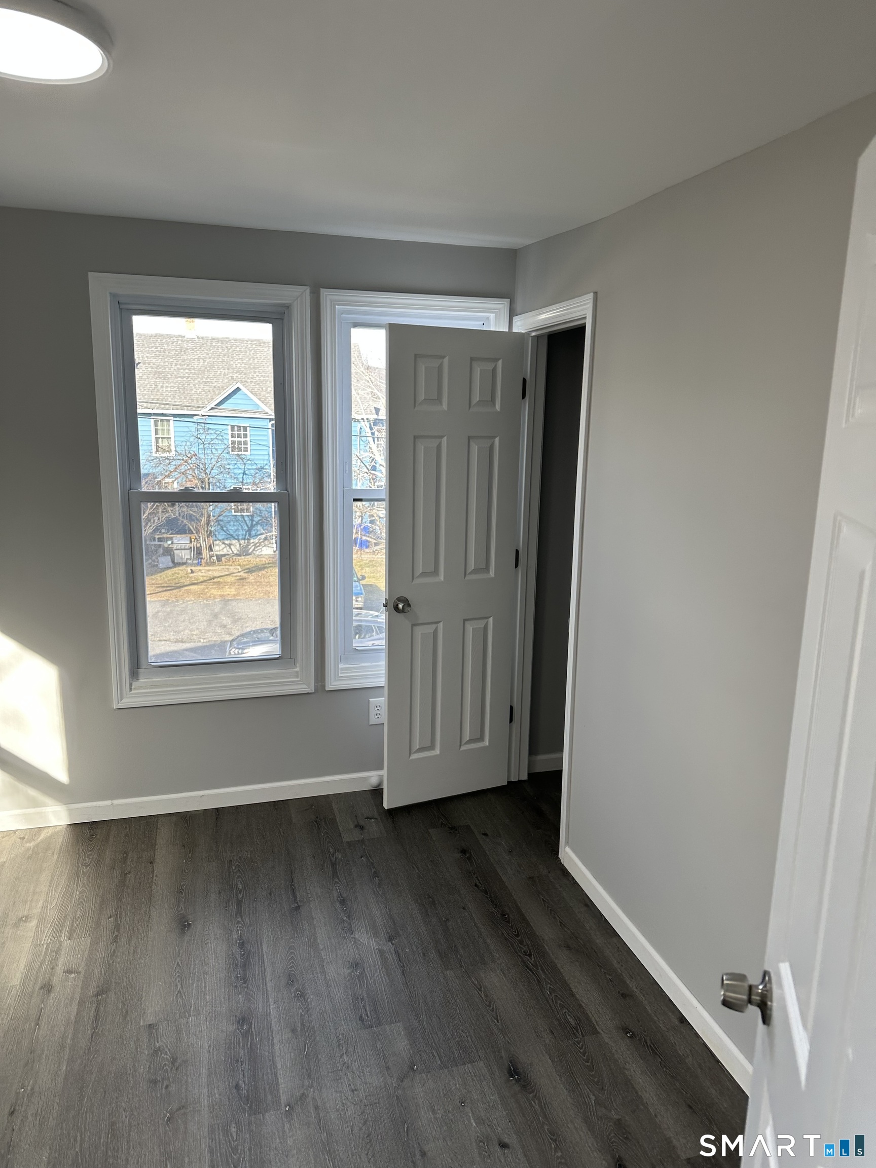 93 Culvert Street Torrington, CT 06790 - Photo 8 of 11 an empty room with wooden floor and windows