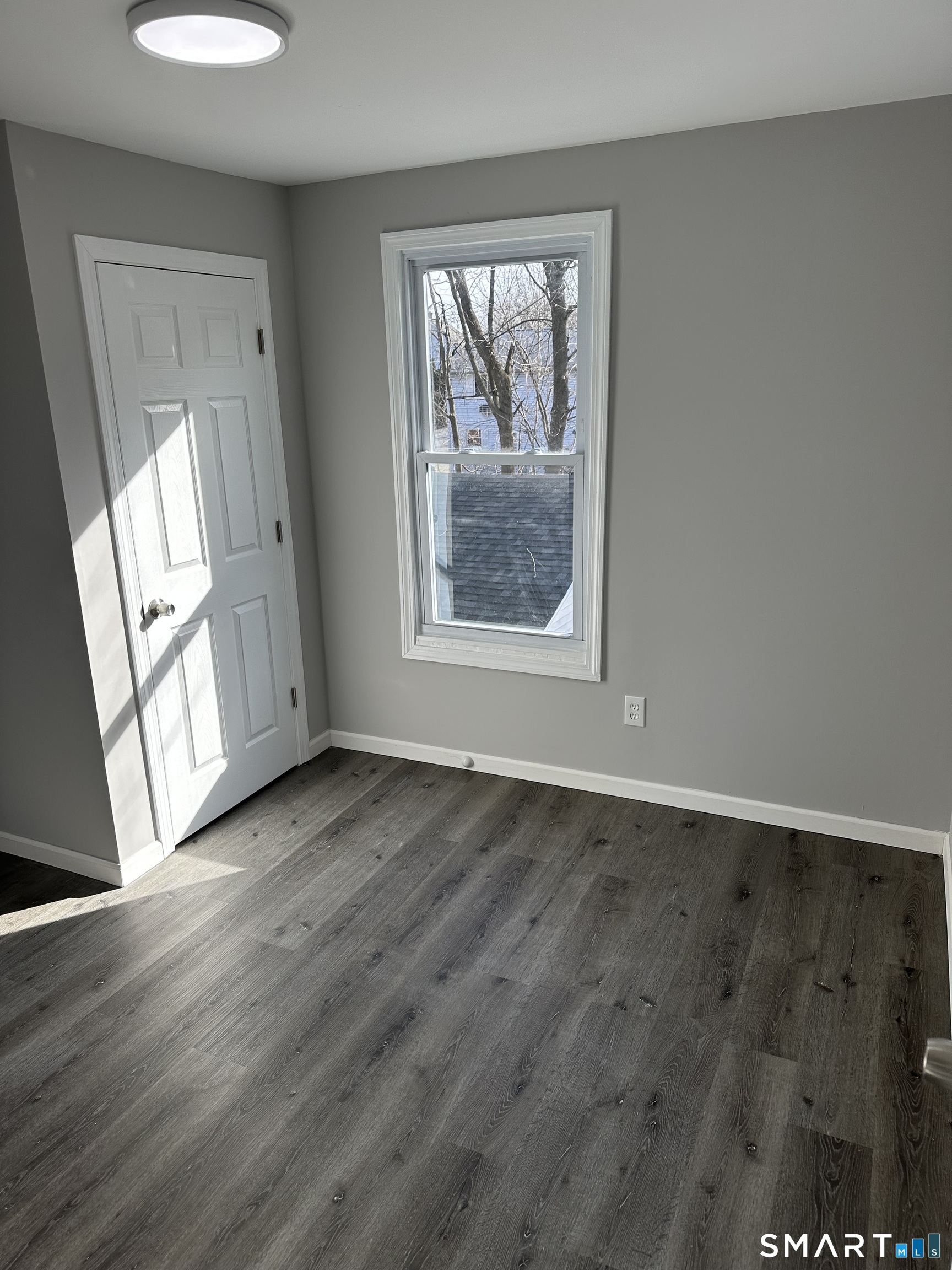 93 Culvert Street Torrington, CT 06790 - Photo 9 of 11 an empty room with wooden floor and windows