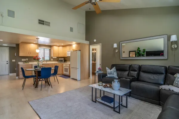 a living room with furniture a dining table and kitchen view