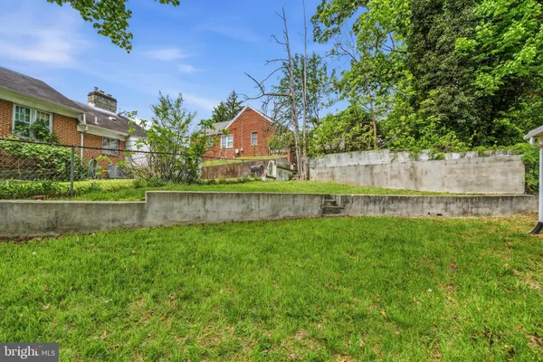 a view of a house with a yard and wooden fence