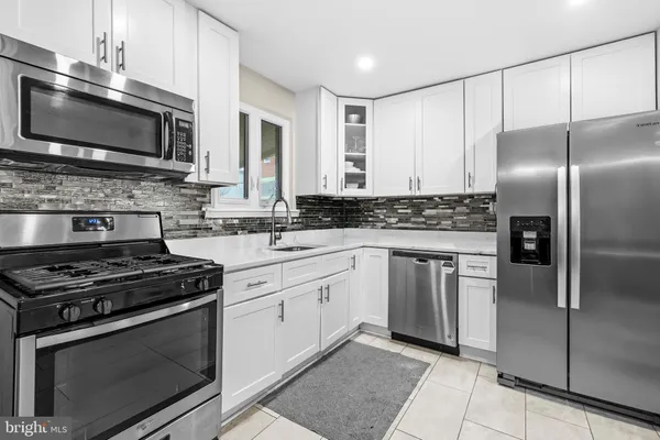a kitchen with granite countertop a sink stove and refrigerator