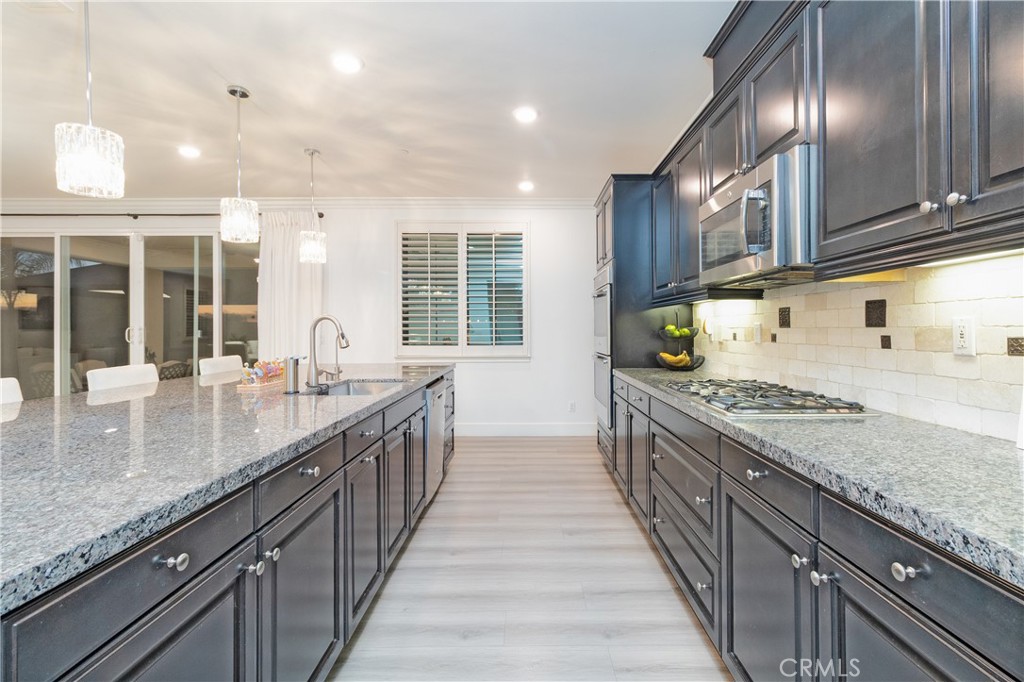 13866 Sweet Avenue Riverside, CA 92503 - Photo 9 of 69 a kitchen with granite countertop stainless steel appliances a sink stove top oven and cabinets