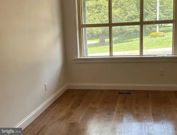 a view of a room with wooden floor and a window