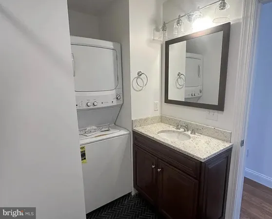 a bathroom with a granite countertop sink toilet and mirror