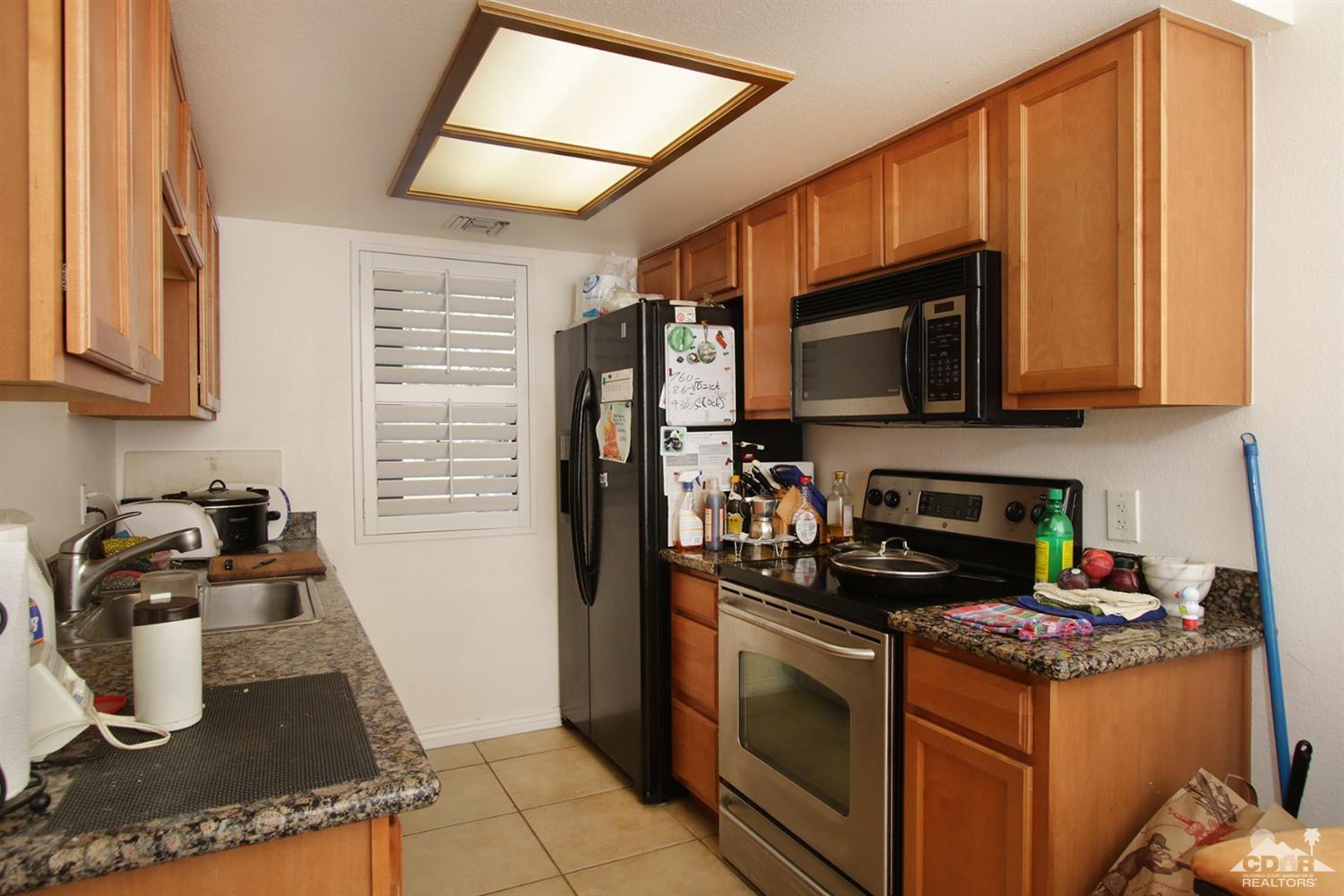 43376 Cook Street, Unit 96 Palm Desert, CA 92211 - Photo 1 of 29 a kitchen with a stove a microwave and refrigerator