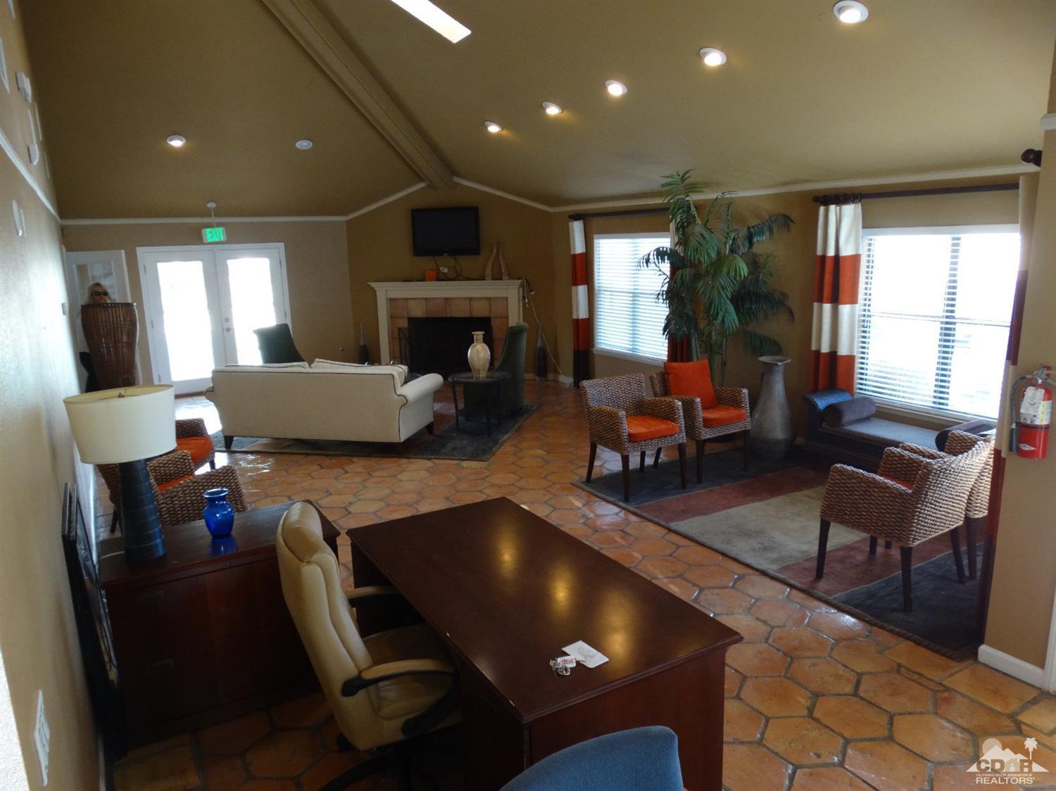 43376 Cook Street, Unit 96 Palm Desert, CA 92211 - Photo 21 of 29 a living room with furniture a fireplace and a dining table with wooden floor