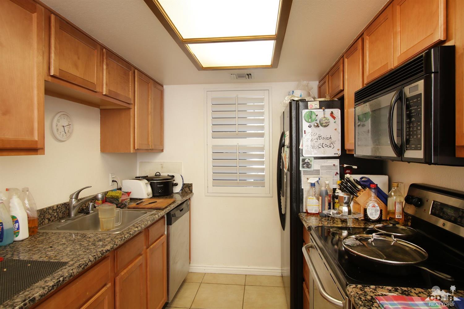 43376 Cook Street, Unit 96 Palm Desert, CA 92211 - Photo 3 of 29 a kitchen with a sink stove and cabinets