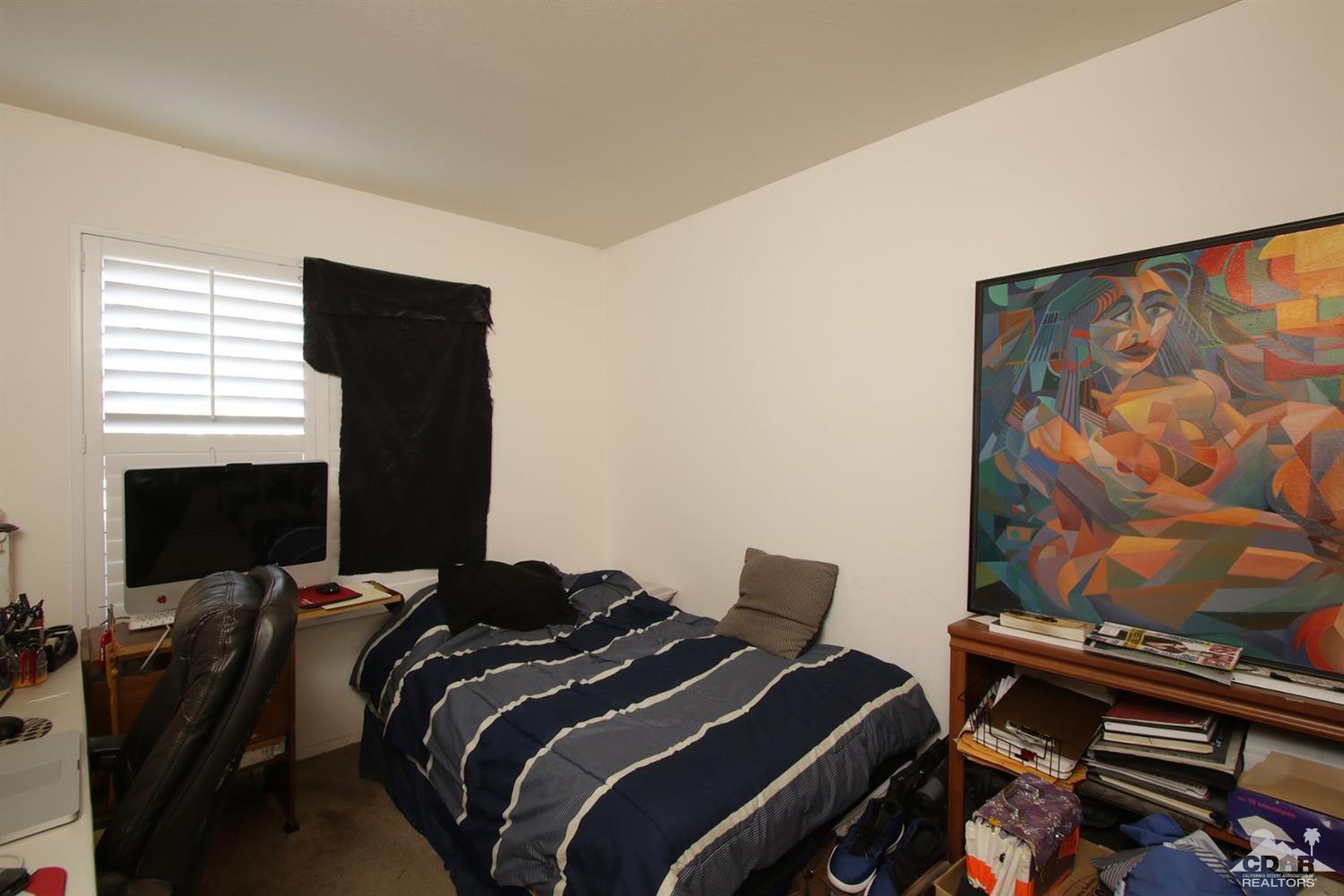 43376 Cook Street, Unit 96 Palm Desert, CA 92211 - Photo 8 of 29 a bedroom with a bed and a flat screen tv