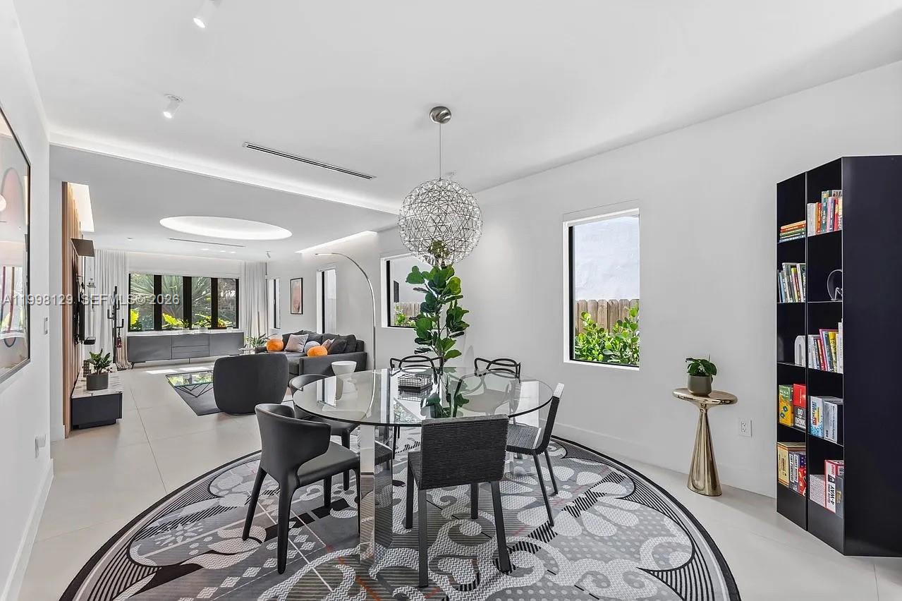 445 Northeast 76th Street Miami, FL 33138 - Photo 13 of 63 a dining room with furniture a rug and a chandelier