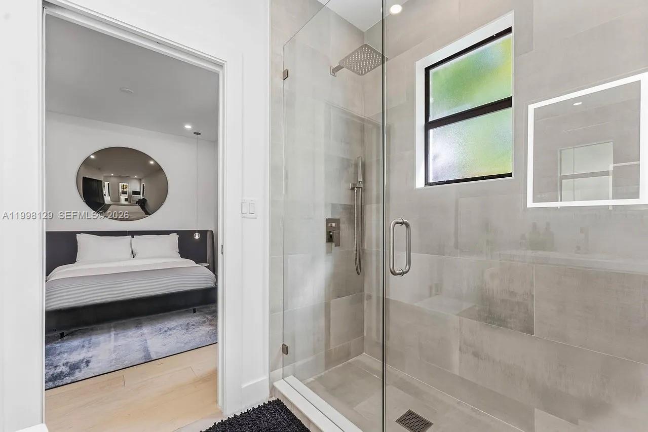 445 Northeast 76th Street Miami, FL 33138 - Photo 17 of 63 a en suite bathroom with a granite countertop sink mirror and shower