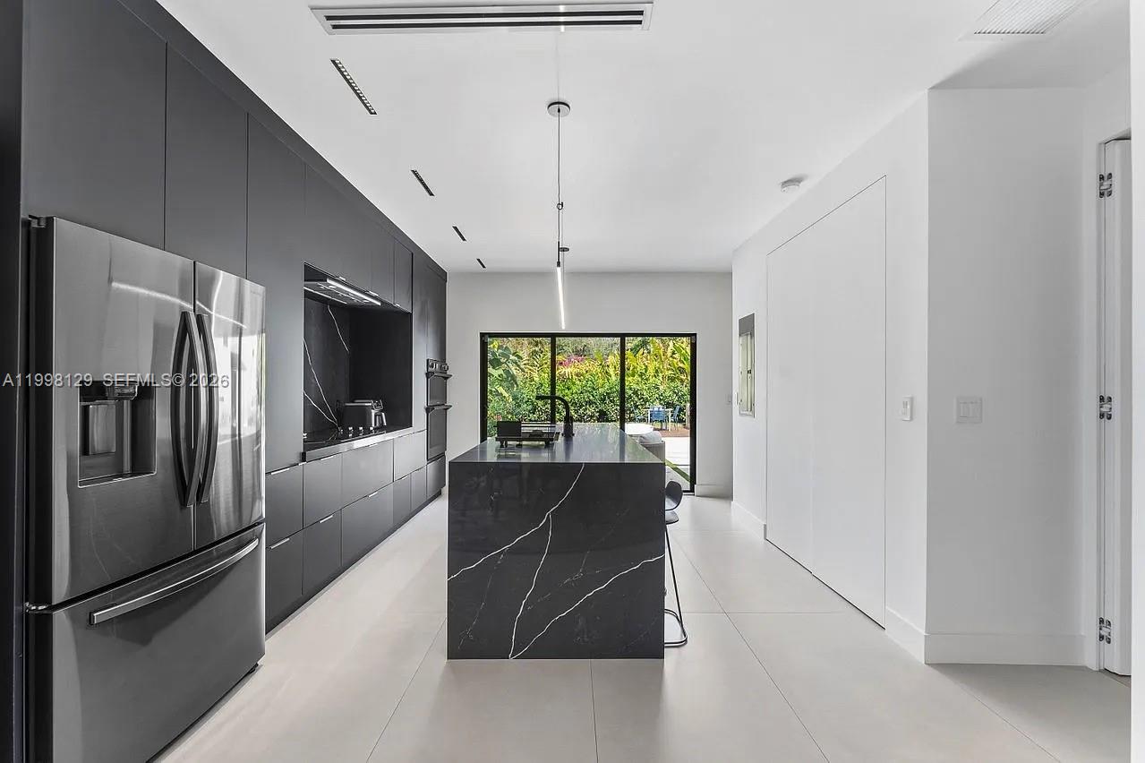 445 Northeast 76th Street Miami, FL 33138 - Photo 26 of 63 a kitchen with stainless steel appliances granite countertop a refrigerator and a view of living room