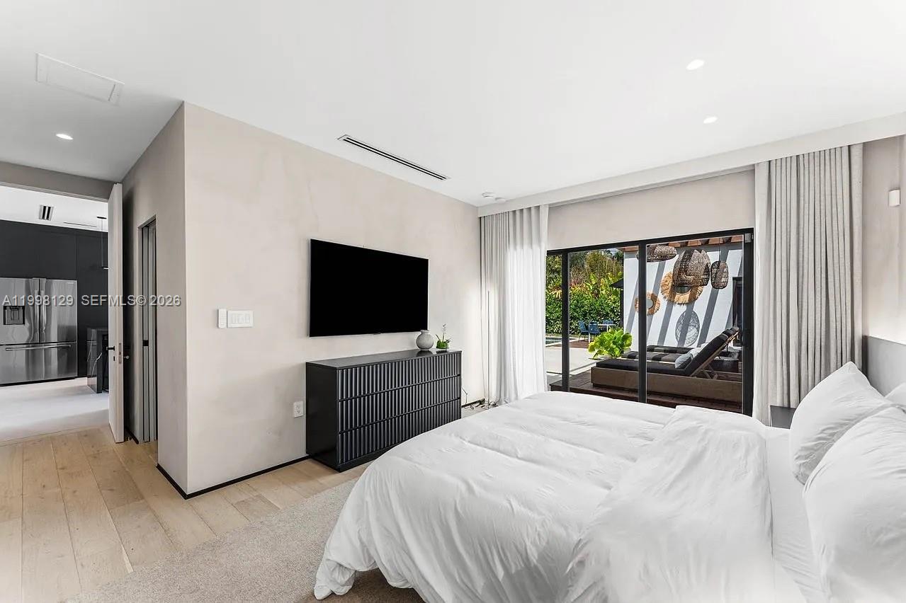 445 Northeast 76th Street Miami, FL 33138 - Photo 29 of 63 a bedroom with a large bed and a flat screen tv