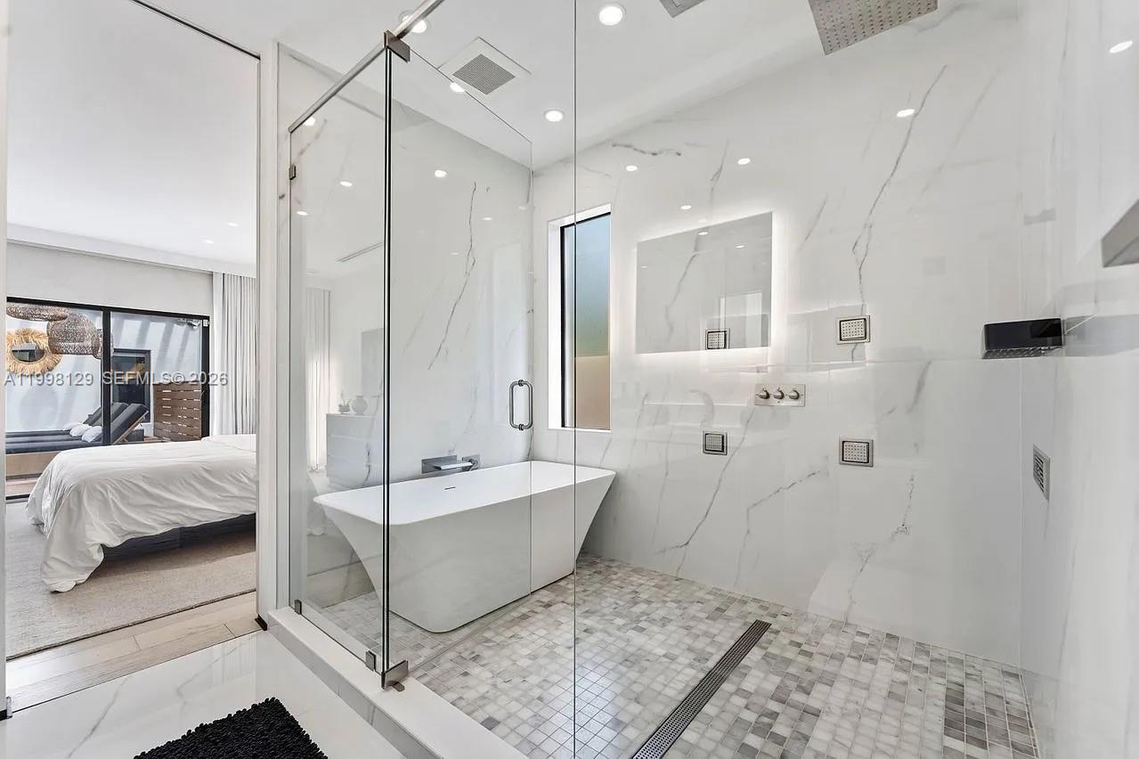 445 Northeast 76th Street Miami, FL 33138 - Photo 31 of 63 a bathroom with a tub shower and mirror