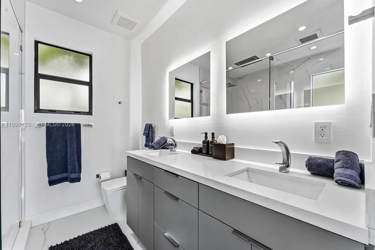 445 Northeast 76th Street Miami, FL 33138 - Photo 32 of 63 a bathroom with a double vanity sink and a mirror