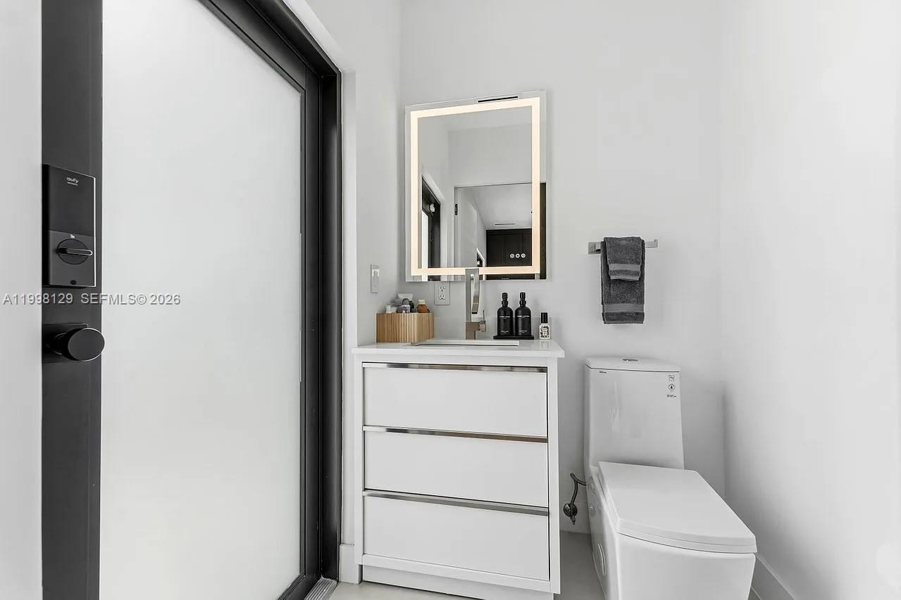 445 Northeast 76th Street Miami, FL 33138 - Photo 35 of 63 a bathroom with a toilet sink and mirror