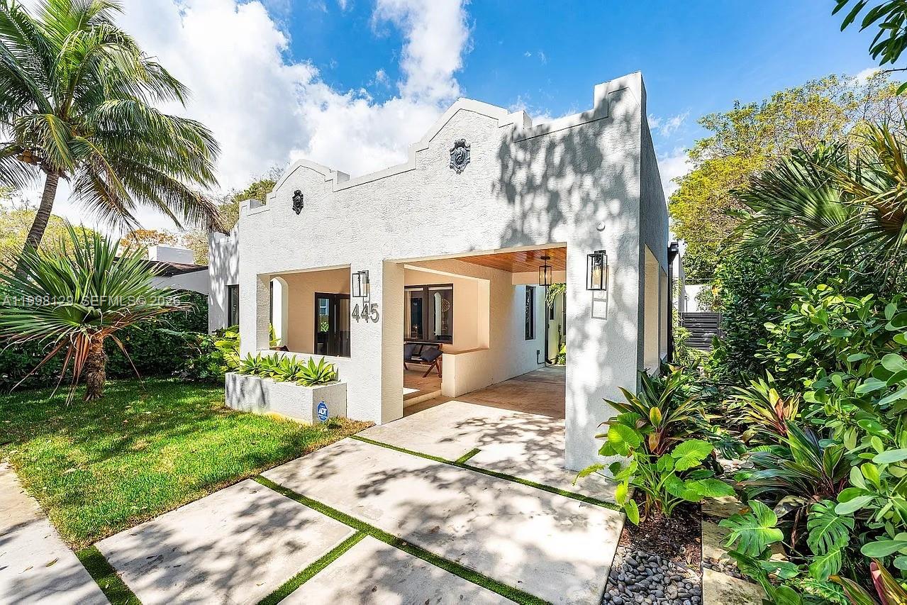 445 Northeast 76th Street Miami, FL 33138 - Photo 4 of 63 a view of a white house with a yard and potted plants