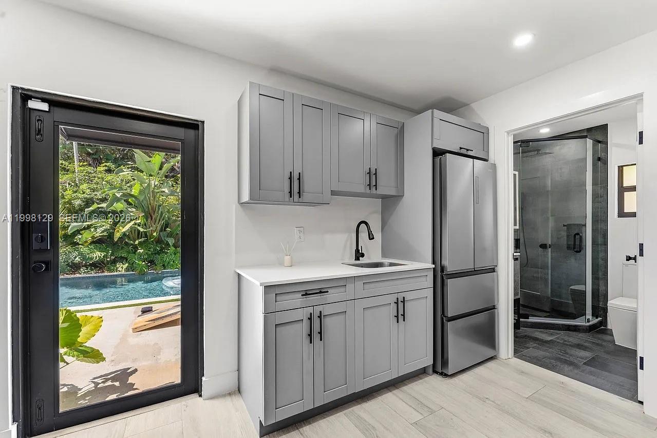 445 Northeast 76th Street Miami, FL 33138 - Photo 45 of 63 a kitchen with a refrigerator sink and cabinets