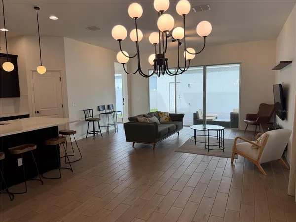a living room with furniture a flat screen tv and kitchen view