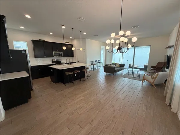 a living room with furniture a fireplace and a chandelier