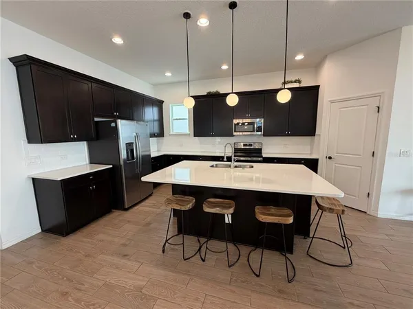 a kitchen with a sink a counter space and stainless steel appliances