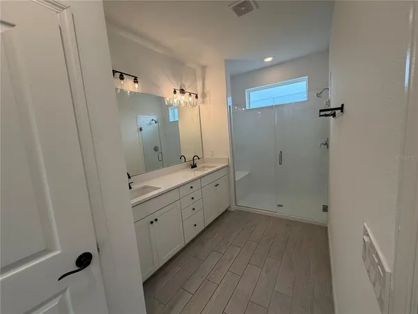 a bathroom with a double vanity sink and mirror