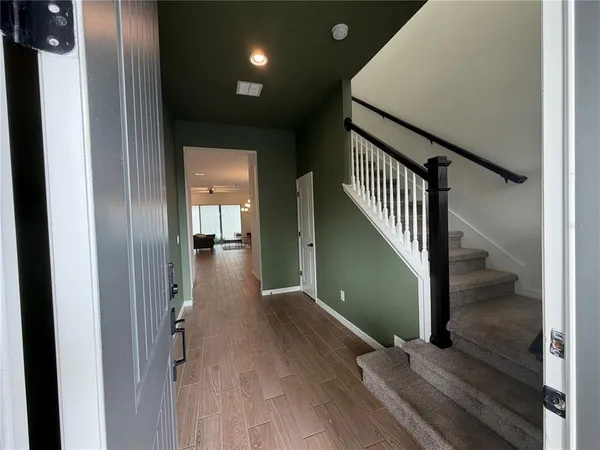 a view of a hallway view with wooden floor and staircase