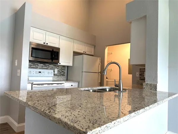 a view of kitchen sink microwave and stove