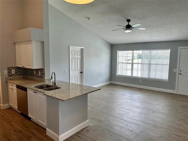 a kitchen with stainless steel appliances granite countertop a sink stove and wooden floor