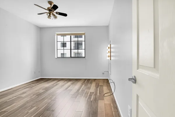 a view of a hallway with wooden floor and windows