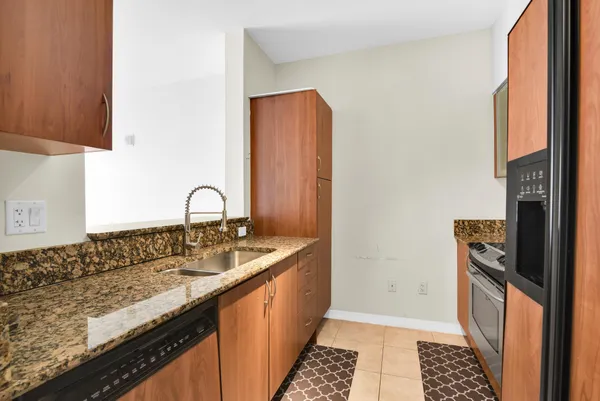 a kitchen with granite countertop a sink and a stove top oven
