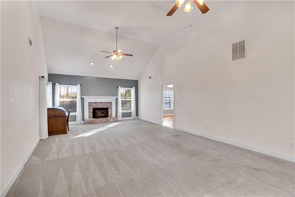 523 Barhams Ridge Drive McDonough, GA 30252 - Photo 12 of 43 an empty room with windows fireplace and a chandelier fan