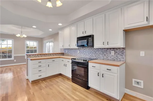 a kitchen with granite countertop white cabinets white stainless steel appliances with a sink and dishwasher