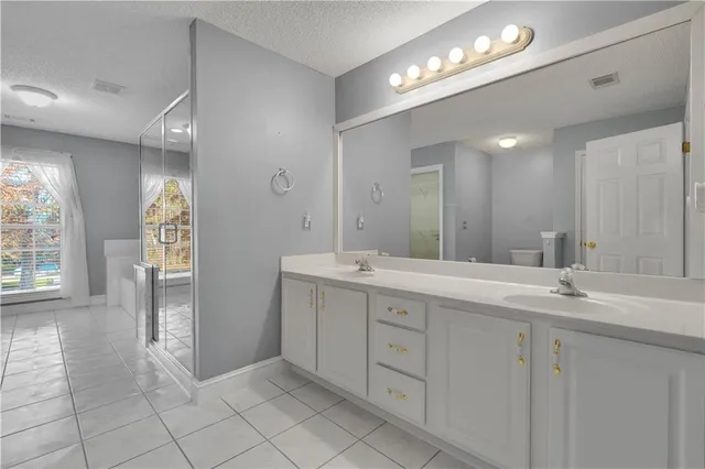 a spacious bathroom with a double vanity sink and a mirror