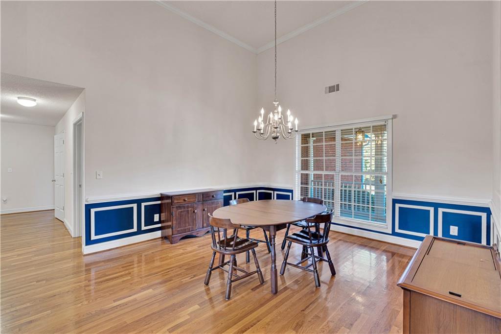 523 Barhams Ridge Drive McDonough, GA 30252 - Photo 22 of 43 a dining room with wooden floor a chandelier a wooden table and chairs