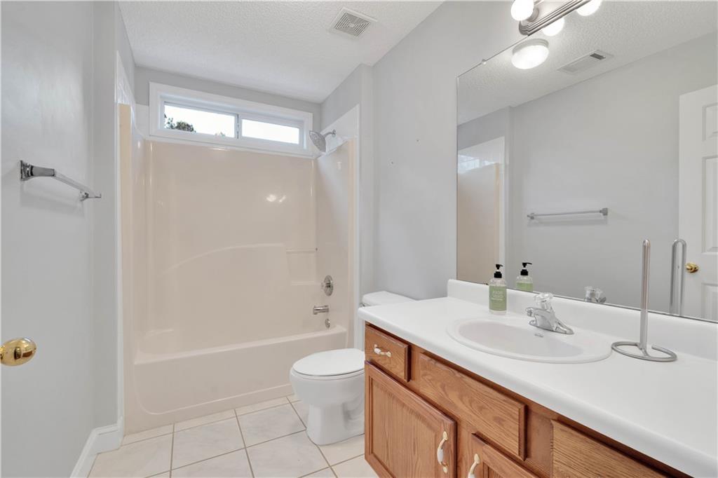 523 Barhams Ridge Drive McDonough, GA 30252 - Photo 30 of 43 a bathroom with a granite countertop sink a toilet and shower