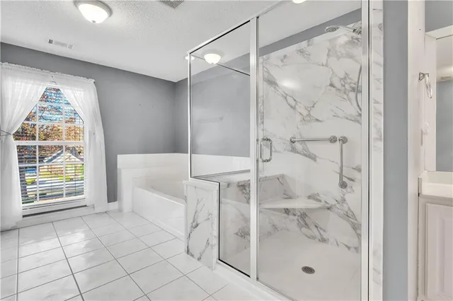 a bathroom with a glass shower door and a window